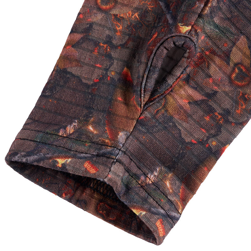| omg_a_hole.JPG | Close-up of a sleeve or cuff of a patterned garment on a white background, showing a dark abstract print with orange, red, brown, and muted green tones.