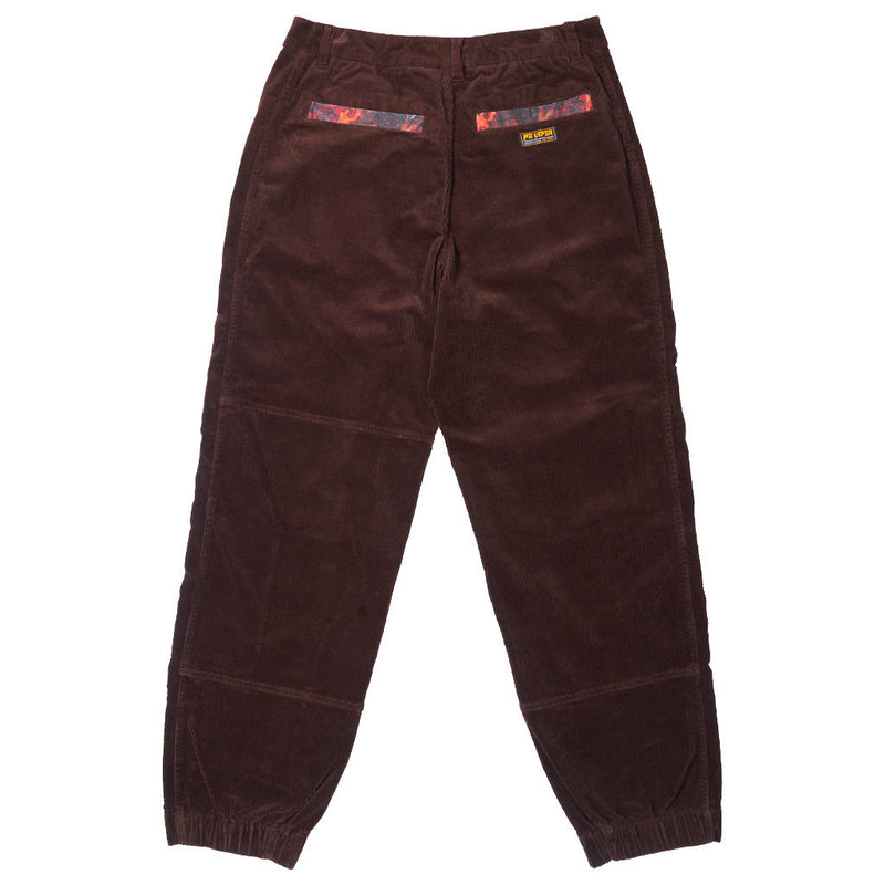 | it_the_back.JPG | A pair of dark brown corduroy pants with elastic cuffs, shown flat against a white background. The back view features two decorative patterned fabric pockets near the waistband and a small yellow brand label.