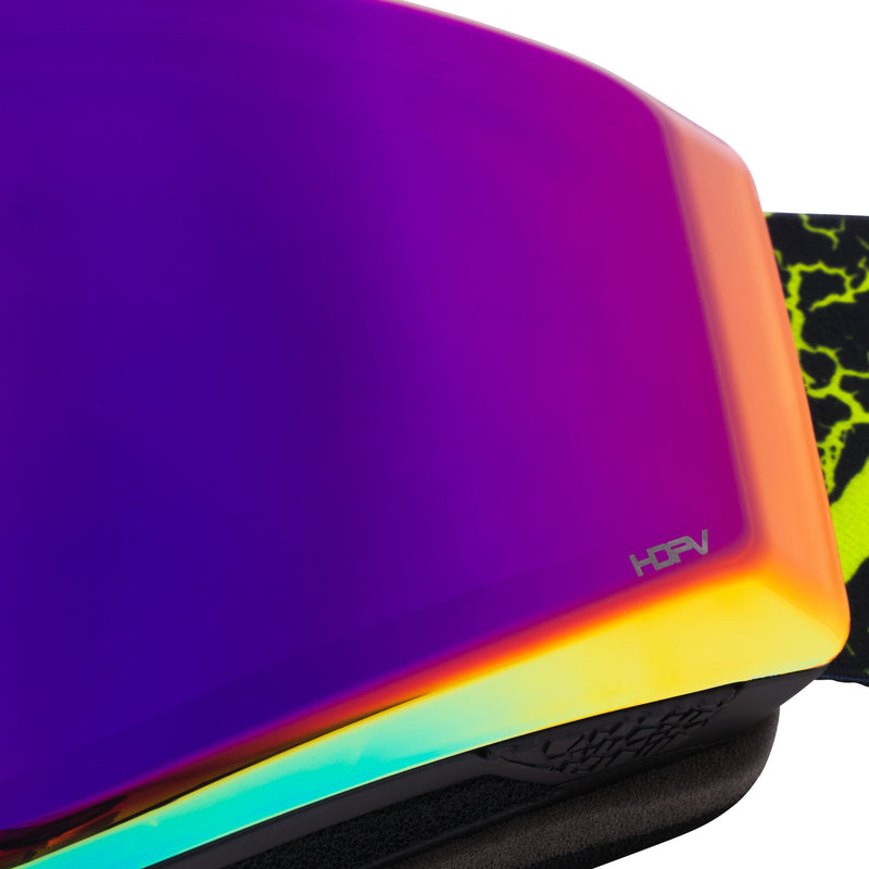/ HDPV Pink-Purple | another_closeup.JPG | Close-up of ski goggles showing a vibrant iridescent purple and orange reflective lens with a small 'HFAV' logo, alongside a black and neon yellow patterned strap.