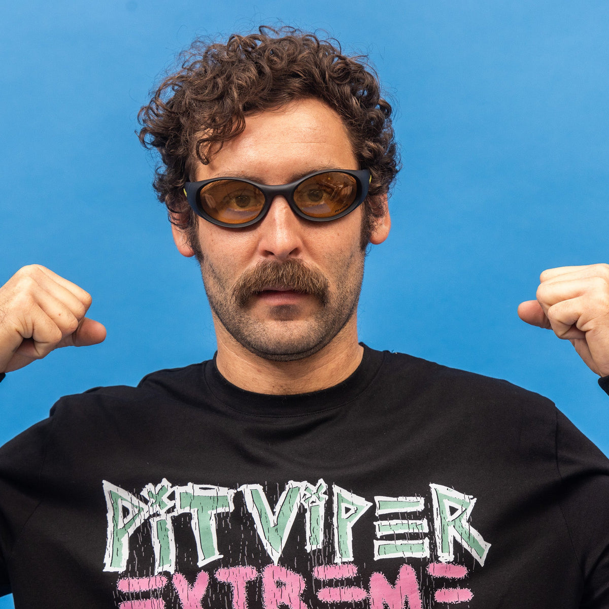 Man wearing sunglasses and a black hoodie with 'Pit Viper Extreme' text against a blue background