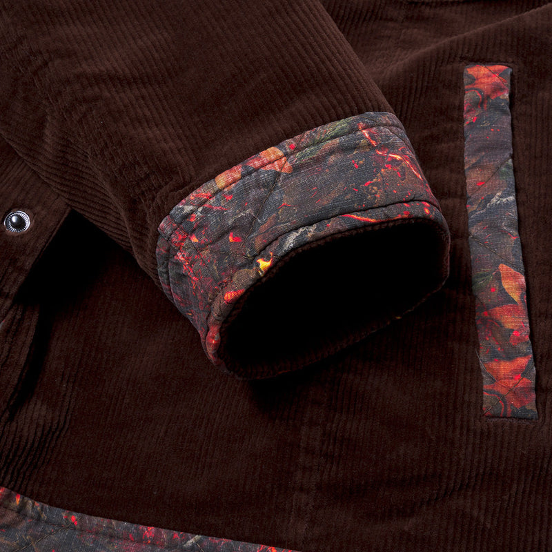 | detail_shot.JPG | Close-up of a dark brown corduroy jacket with a rolled cuff showing a multicolor abstract patterned lining, and a matching patterned fabric detail on the sleeve.