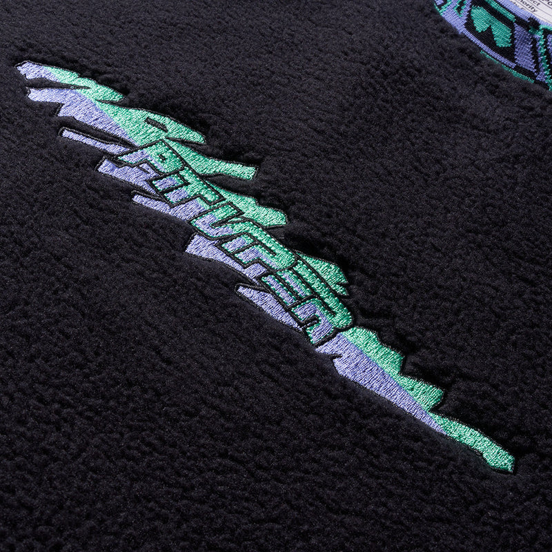 | im_ready_for_my_closeup.JPG | Close-up of a black textured fleece or sherpa fabric with a stylized embroidered graphic in mint green and light gray.