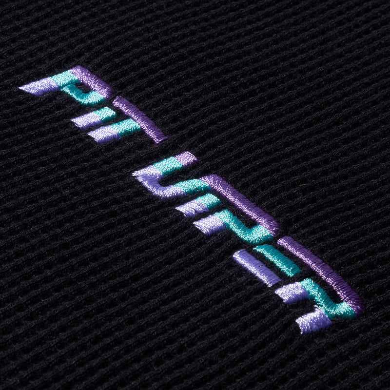 | its_a_logo.JPG | Close-up of a black textured fabric with a stylized embroidered logo in iridescent purple, blue, and teal thread.