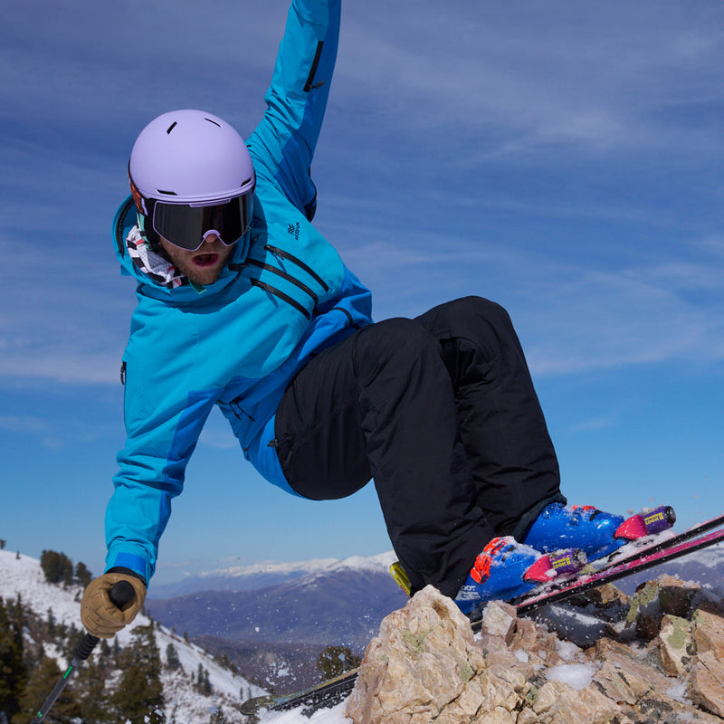 / Smoke | how_much_wood_can_chuck_chuck.JPG | A close-up of a person outdoors in the snow wearing a light purple knit beanie and ski goggles with a black strap featuring orange and white 'PIT VIPER' branding.
