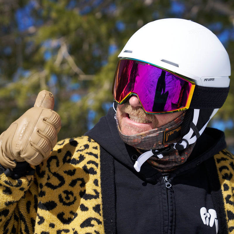 A ma with a mustache wearing a white ski helmet, a leopard sweater and the BN5000 goggles from Pit Viper.