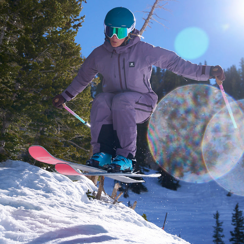 | mega_air.JPG | A skier in a light purple ski suit, blue helmet, and mirrored goggles jumps a snowy slope, with trees in the background and a lens flare overlay.