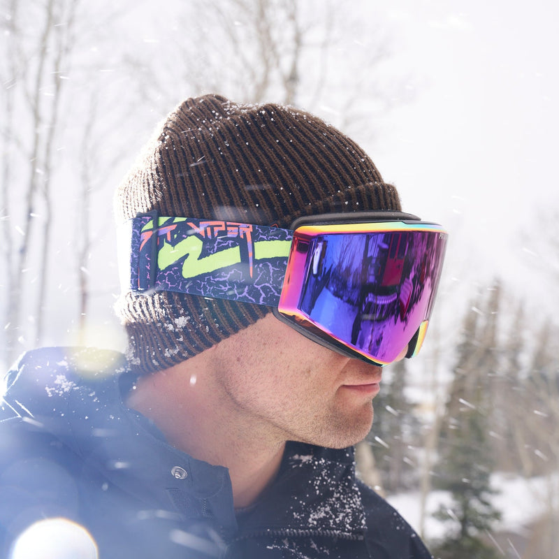 / HDPV Pink-Purple | sup_nick.JPG | A man wearing a dark brown knit beanie and colorful ski goggles with a reflective purple and pink lens, standing outdoors in the snow.