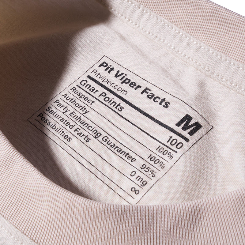 | health.JPG | Close-up of the inside collar of a light beige t-shirt showing a printed nutrition-style label that reads 'Pit Viper Facts' with size 'M' and humorous facts.