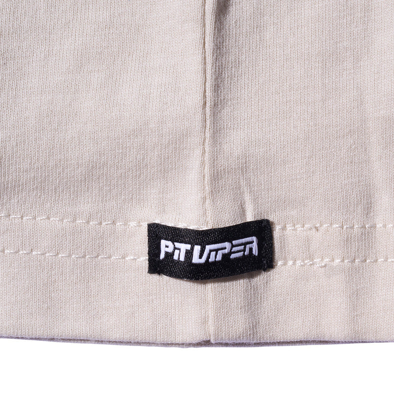 | its_a_logo.JPG | Close-up of a light beige knit fabric garment with a black rectangular brand tag reading PIT VIPER in white text, stitched near the hem.