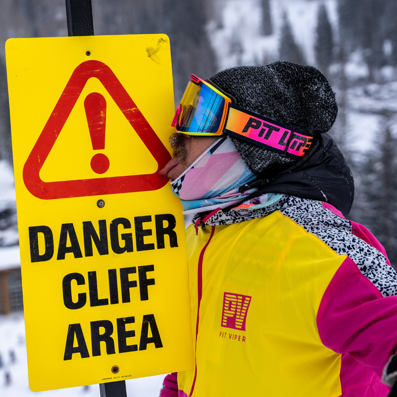  | chicken_thigh.JPG | Man licking a ski resort sign wearing the Italo Proform Goggle By Pit Viper Sunglasses