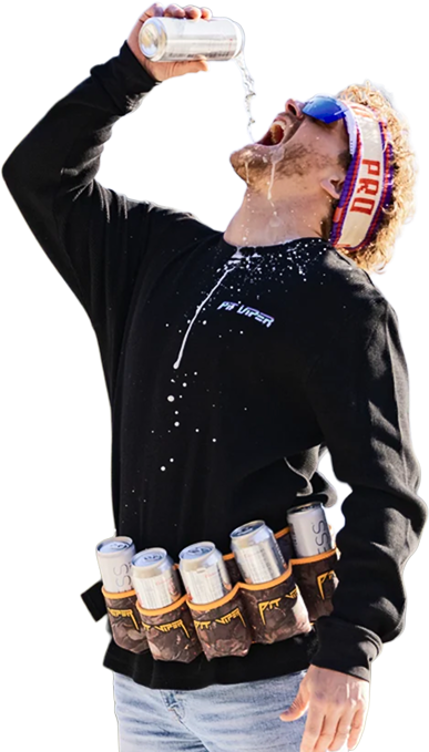 A man wearing a black long-sleeve shirt with 'Pit Viper' printed on the chest, blue jeans, and a white headband with 'PRO' in red and blue. He is tilting his head to drink from a silver can, with liquid spraying from his mouth and multiple cans strapped around his waist.