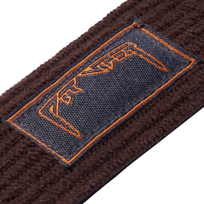 Close-up of a dark brown textured knit strap with a rectangular navy blue woven label outlined in orange stitching and orange embroidered lettering.