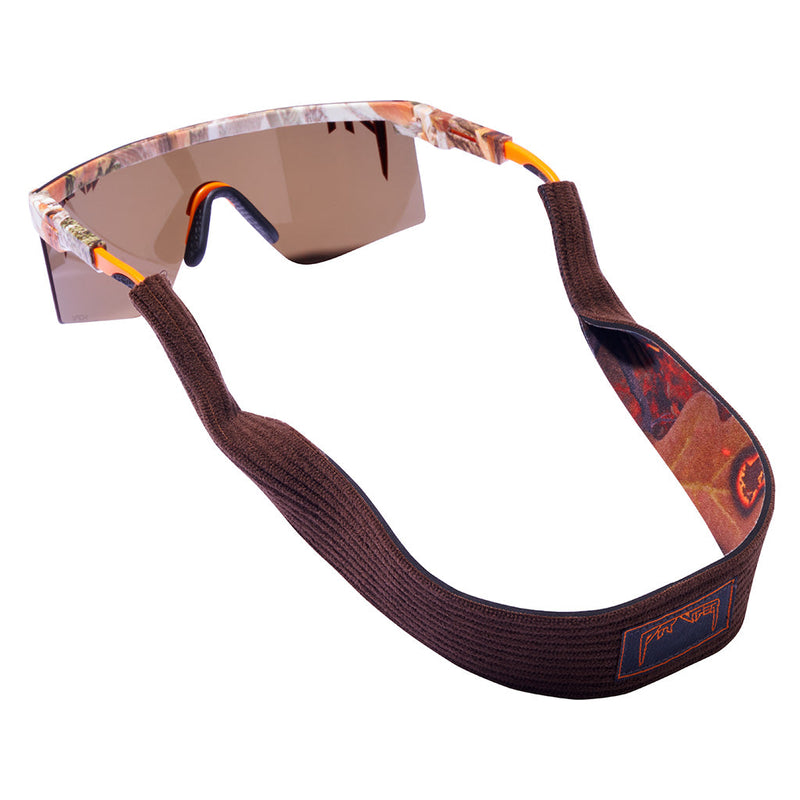 Shield-style sunglasses with a brown knit strap, brown mirrored lenses, and a camouflage-patterned frame with orange accents, shown on a white background.